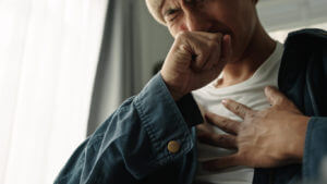 Man is suffering from painful chest pain and cough as a result of a chronic lung disease called emphysema.